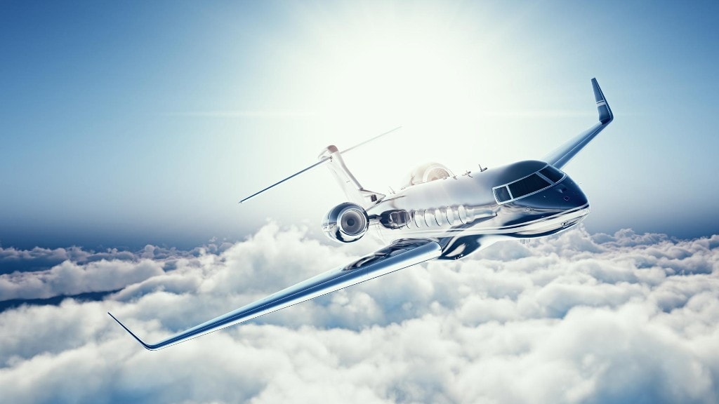 Business jet climbing into a colorful sunset sky